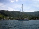 Spruce at anchor in Taganga Bay with high land behind