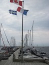 Yacht pontoon at Havre Amherst: flags are Canadian, Quebec Province (left), Acadian (right).