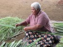 Mary stripping the sharp edges off the Panadanas leaves ready for processing for mat weaving.