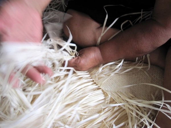 Weaving a Pandanas mat.