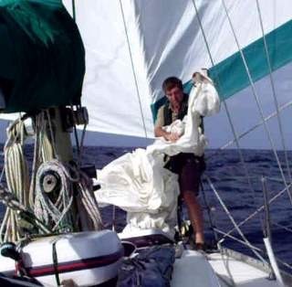 Andy roigging the storm jib as a staysail to reduce the rolling while running in the trade winds with twin boomed out headsails.