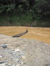 A long canoe beaches ready to take on passengers. In the dry season the river is a beautiful blue.