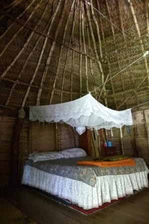Inside the traditional bure  -  a very luxurious bed rather than mats on the floor.