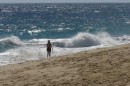 Beth strolls along Lovers Beach as the big Pacific side surf rolls in.