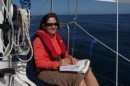 Beth reading on the foredeck  -  studying up on cool things to do in San Fran.