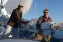 Norm & Ryan bundle up the main and put it away as the wind gusts to 32 knots.  The genoa alone is enough sail!