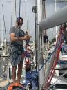 Jovan prepares to climb the mast: He is using his rock climbing equipment since the bosun chair could not reach the top of the mast where the problem was located.