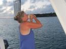 Karrie blowing the conch horn at sunset