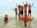 Maunaira kids on some sort of floaty toy -clothing optional for this day at the beach!