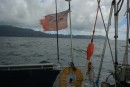 Our ragged ensign appraoches the coast of Hiva Oa