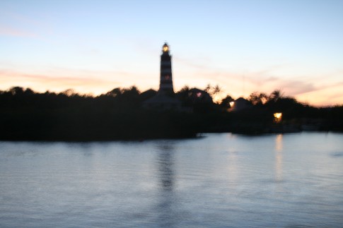 Light house at sunset taken from a moving boat, Hope Town harbour, Bahamas