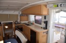 The galley is equipped with three polished stainless steel sinks mounted under Corian countertops. There is an ENO three burner stove with a separate oven.