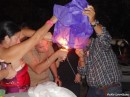 Party guests lighting one of many Chinese lanterns that were sent aloft