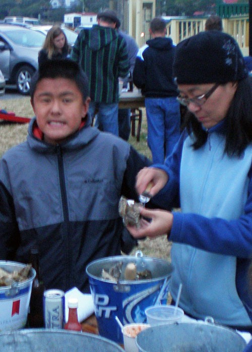 Quanmin digging in and shucking oysters but Nicky is not quite so sure....