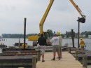 A crane lifts the spud that anchors the its barge in place.