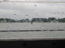 A photograph of Robert heading in to town in the rain taken from inside the nice dry boat.
