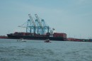 A loaded container ship and the cranes that move its cargo. In the foreground that