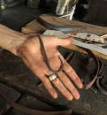 A visit to the blacksmith shop at Tryon Palace.: A helper displays a fish hook formed by the blacksmith.