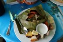 Mahi Mahi and shrimp steamed in a banana leaf, with coconut sauce and breadfruit.