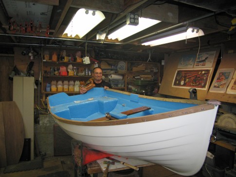 Here is Bart just after he finished planning the new rail to follow the sheer line of the boat.  

Making sure the new rail followed the designed sheer line was a critical aspect of this refurb project.  The sheer line contains a lot of the personality of this cute little boat.

In this photo you can also see the plug I made for the dagger board trunk.  There is a teak dagger board for use when sailing but it can