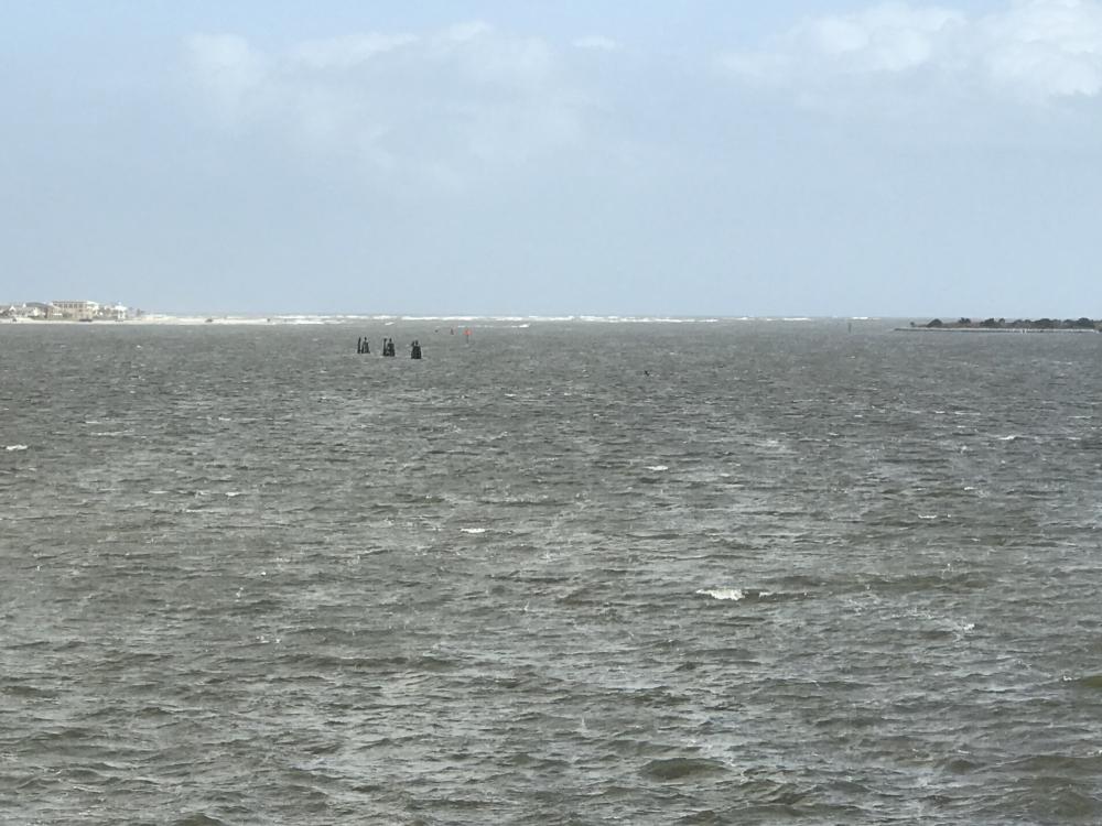 St Augustine Inlet with North wind: The channel is to the far right. All that white stuff way out there are breaking waves in the shallow water just north of the channel.