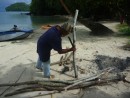 Back on the beach, Sikki began cutting the firewood to size with his machete.
