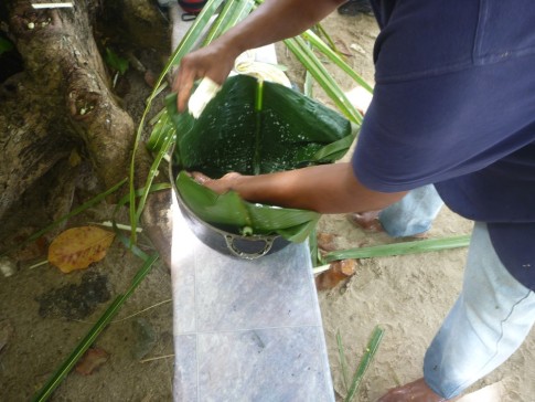 Sikki placed a couple of unripped banana leaves into a pot and wet them with coconut milk. The coconut milk acted as an anti-stick due to its high fat content.