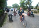 locals balance their baguettes and fresh fruit on their bicycles after their early morning trip to town for groceries 