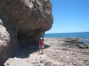 Dwarfed by eroding rocky cliffs along the beach 