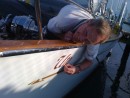 We can blame it all on Dennis. Here he uses his finger nails to scratch off the boat