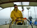 Mark looking over the sail trim and steering the boat