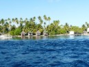 thatched cabins on waters edge near the pass into Fakarava