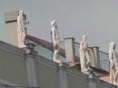 Statuary lining the roof of a modern building.