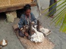 Iket weaving demonstration in Maumere - flattening the cotton between rollers