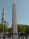Egyptian obelisk monument with loudspeakers on minarets of Blue Mosque on the left.