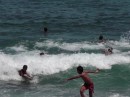 children having a grand time surfing the waves on planks of wood