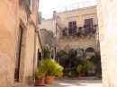Ragusa: Ibla street corner in a residential area -many balconies have planters filled with green.