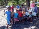 Children help haul up the dinghy then turn round for a photo, Ambrym