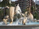 Statue of happy dolphins leading bronzed tourists to a wonderful vacationland, Mazatlan.