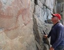 On the left a cliff face with a pictograph some hundreds of years old, on the right just an old guy.