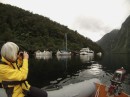 Barefoot amid the fishing boats, and a cruise boat, at Deep Cove, at the head of Doubtful Sound