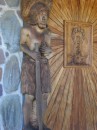 Wood carved door and carved statue at front of Catholic church.