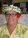 This smiling Cook Islander, a cashier at the supermarket, proudly wears both a wreath of flowers atop her head AND a single blossom over her left ear.  