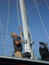 Jim hauls on the halyard while a boatyard worker goes up the mast to secure it at the top for the extraction.