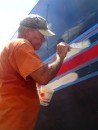 Meanwhile, work on the boat progresses. Here Jim applies primer paint to the stripes on the topsides. 
