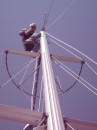 Jim works atop the mast far above the wagon wheel.