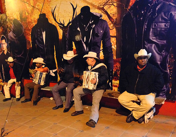 Mariachi street band taking a break against a perfect store-wall backdrop!