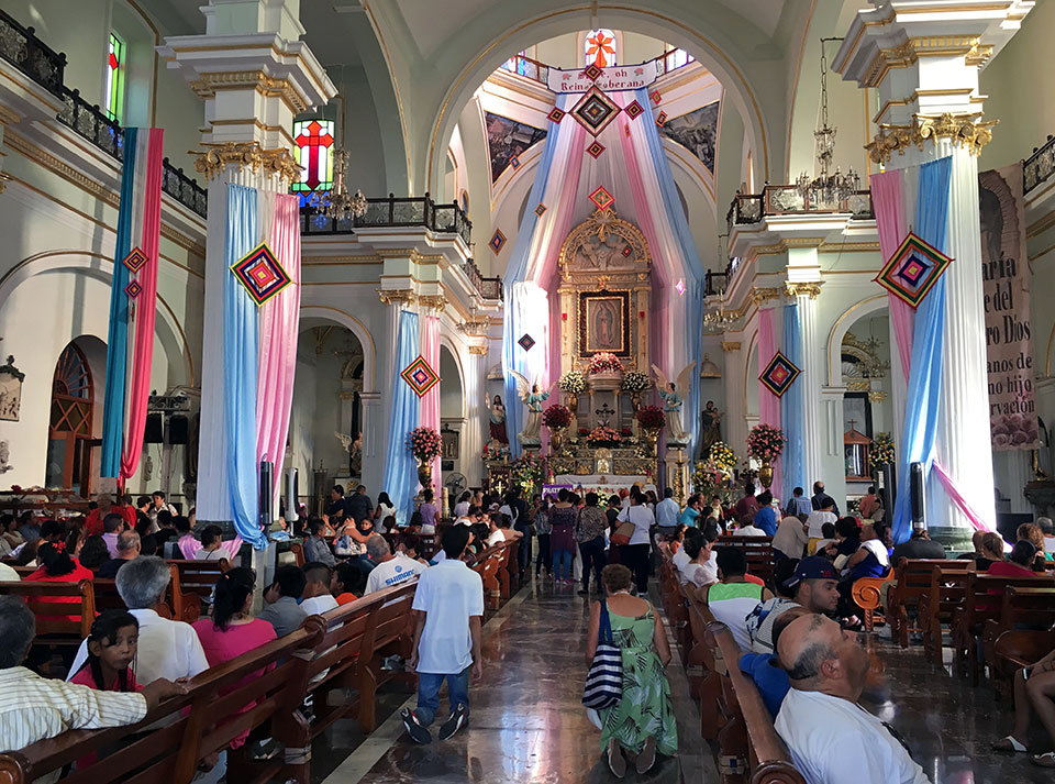 The inside of La Iglesia de Nuestra Senora de Guadalupe, decorated in pink and blue. Many of the pilgrims crawled in on their knees, like these two in front of us.  The church bells ring for every pilgrim entering the church, which was pretty much non-stop.