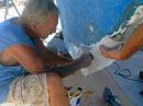 George and Kirk lay down the first layers of fiberglass matting on the leading edge of the keel. Many more layers to go…