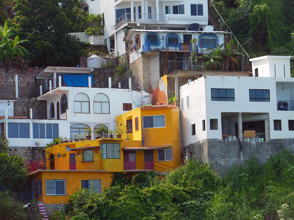 More seaside villas clinging to the jungle cliff walls, accessible only by boat or hiking trail.